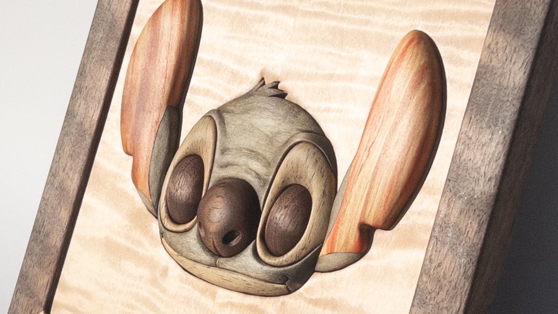 Hand-carved blue alien character portrait in curly maple with walnut frame